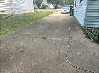 A concrete driveway grayed by years of dirt, algae and tire traffic